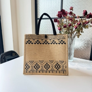 Detail of jute tote bag with ethnic geometric pattern and rustic texture on white surface