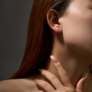 Detailed close-up of a S925 silver stud earring with gold finish and teardrop opal stone