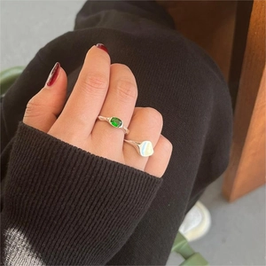 Close-up of a 925 silver ring featuring an oval green gemstone on a model hand