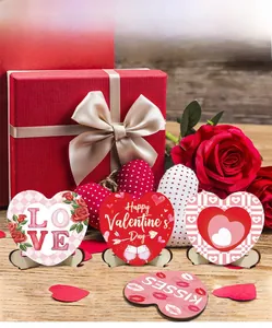 Close-up of heart-shaped wooden Valentine signs with LOVE and rose patterns on stands