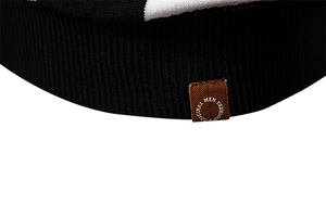 Macro view of black ribbed knit polo shirt with brown decorative brand label