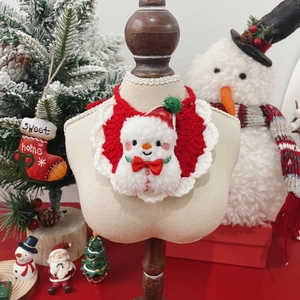 Detail of handmade crochet pet bib with Christmas snowman design and red bow decoration