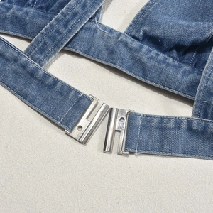 Dettaglio del tessuto denim lavato blu con fibbia in metallo argento e trama di alta qualità