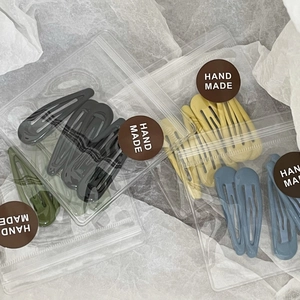 Detail of colorful drip oil teardrop hair clips in multiple colors in handmade packaging