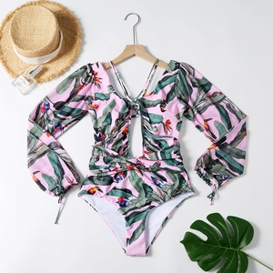 Dettaglio del costume intero rosa a maniche lunghe con stampa tropicale e lacci a V
