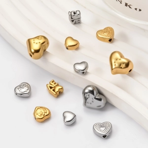 Detailed close-up of gold and silver heart-shaped spacer beads for DIY jewelry making