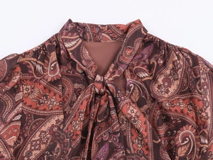 Detail of bohemian paisley chiffon neckline with elegant self-tie bow and subtle pleats