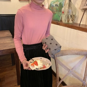 Polka dot gray corduroy makeup bag held by a model wearing a pink sweater and black skirt