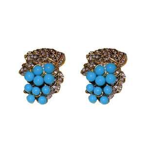 Vintage gold grape leaf earrings with sky blue beads and sparkling crystals on white base