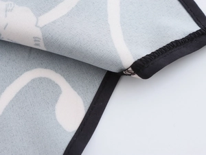 Macro shot showing high-quality black stitched edges and gray patterned textile texture