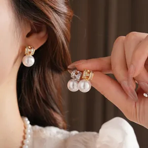 Elegant gold pearl drop earrings with crystal studs shown on model and close-up