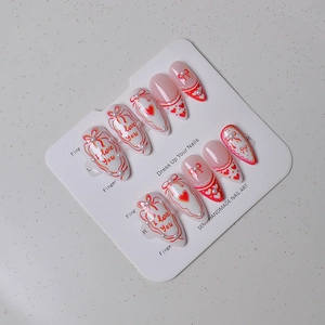 Macro detail of almond nails with hand-painted hearts, bows, and 3D pearls
