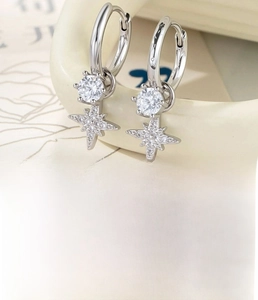Detail view of silver star earrings featuring zircon inlay and 9mm inner diameter clasp
