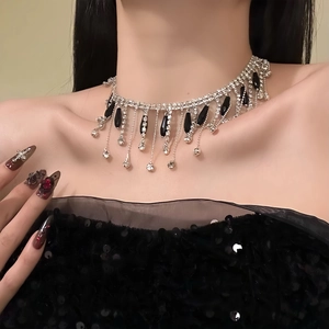 Sparkling crystal tassel choker with black teardrop pendant worn on collarbone