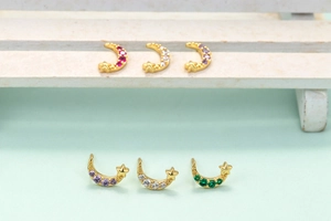 Detailed view of gold moon and star stud earrings with colorful micro-inlaid zircons
