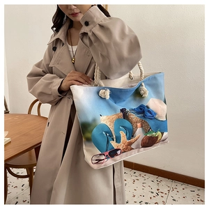 Canvas beach tote bag with blue summer oil painting print and rope handles on model