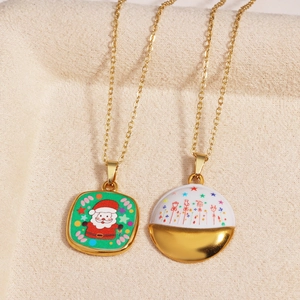 Detail of gold necklaces with festive Santa and Christmas tree charms on beige suede