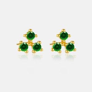 Macro view of gold S925 silver stud earrings featuring three emerald green gemstones