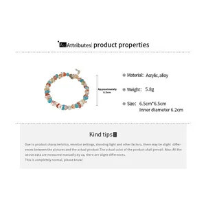 Detail view of colorful acrylic beads and white flower charms on a handmade bracelet