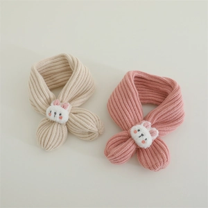 Detail of knitted baby scarves in beige and pink with cute plush bunny decorations