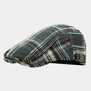 Detail view of plaid newsboy cap with bronze metal buckle and textured dark green fabric