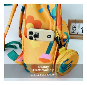 Detail showing side pocket of yellow floral kids backpack holding a smartphone