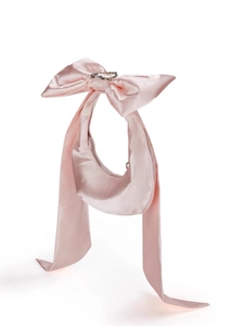 Dettaglio borsa hobo in raso rosa con grande fiocco e fibbia in strass scintillanti