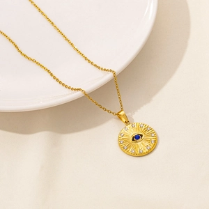 Close-up of golden Evil Eye pendant with blue stone and sparkling white crystals