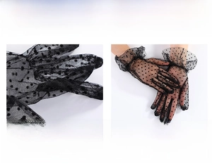 Detail of black polka dot lace gloves showing the elastic wrist and ruffle edge
