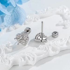 Silver bow heart stud earrings with cubic zirconia inlay on a vintage pedestal
