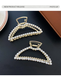 Detail view of elegant golden hair claws featuring delicate pearls and sparkling rhinestones