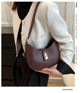 Détail du sac demi-lune vintage marron foncé avec boucle métallique dorée chic