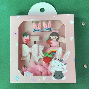 Detail der rosa Geschenkbox mit Hasen-, Erdbeer- und Regenbogen-Haarspangen für Mädchen
