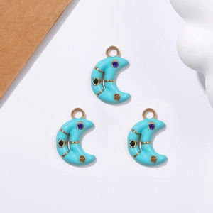 Detailed view of crescent moon pendants with turquoise enamel and colorful rhinestones