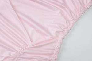 Close-up of pink layered cake dress fabric showing soft pleated texture and elastic waist detail