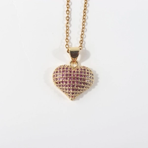 Macro shot of gold-plated heart pendant necklace with micro-pave pink cubic zirconia detail
