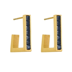 J-shaped gold earrings with dark blue square gemstone on white background