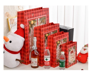 Detailed size comparison of Christmas gift bags with wreath design and red ribbon handles