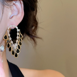 Detail of 18K gold plated teardrop earrings with zircons and black vintage pendants
