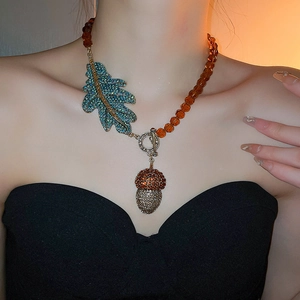 Détail du collier pendentif gland avec feuille de cristal bleu et perles ambrées