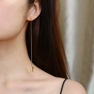 Detailed view of elegant gold threader earrings with geometric rectangular bar pendant