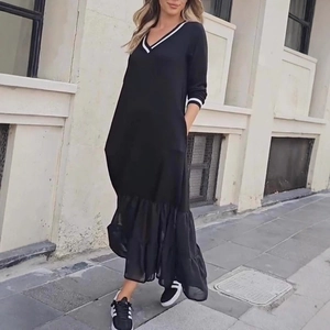 Détail de la robe noire à col en V avec bordure blanche et ourlet plissé en résille