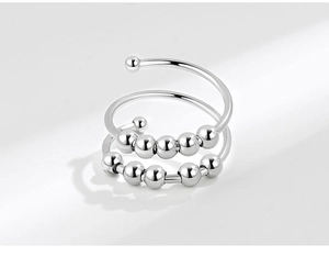 Macro detail of silver spinning anxiety ring with movable beads on a polished band