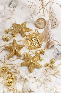 Flat lay of champagne gold star tree toppers and glittery Christmas ornaments set
