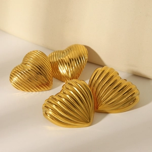 Detailed macro view of 18k gold heart earrings featuring unique vertical linear texture