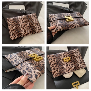 Detail view of leopard print clutch bag showing front lock and interior compartment