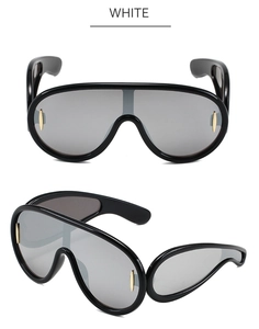 Close-up of oversized black shield sunglasses with silver mirrored lenses and futuristic frame