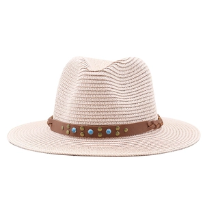 Detail of straw fedora hat featuring a brown band with turquoise beads and brass rivets