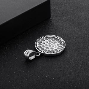 Macro shot of silver hammer-textured round stainless steel pendant with beaded border
