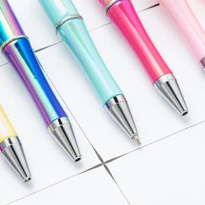 DIY beaded ballpoint pens with vibrant UV gradient finishes and metallic tips on paper